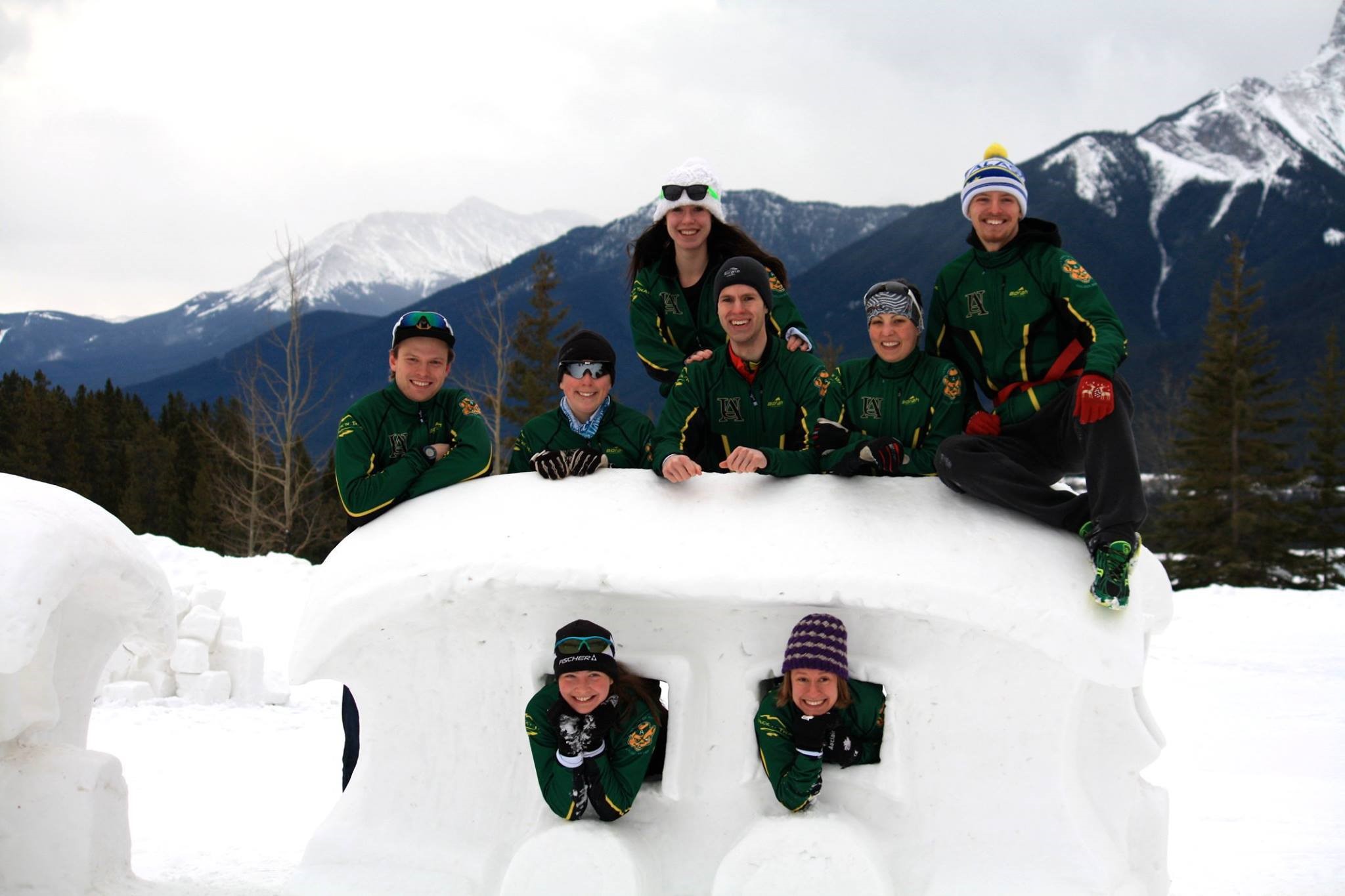 cross-country ski team posing on and through a snow sculpture